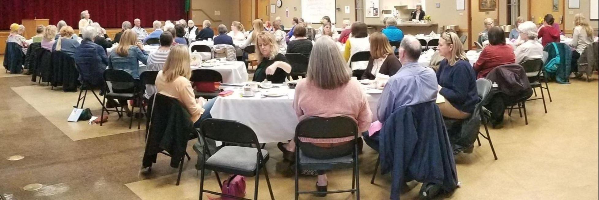people sitting around tables in the Hal Holmes Center