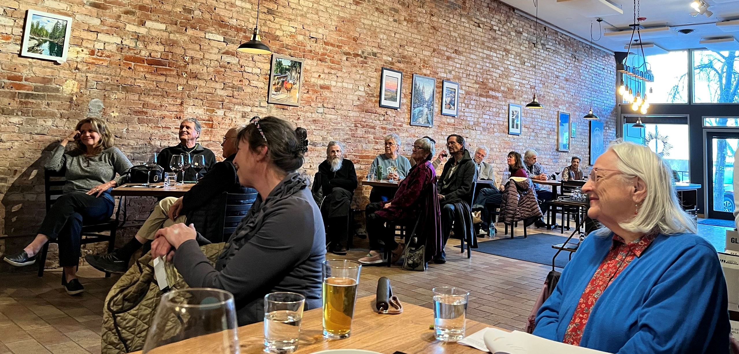 Bricked building with art and people enjoying a poetry reading